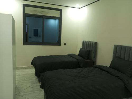 a room with two beds and a mirror on the wall at Appartement Alhoceima in Imejoudene