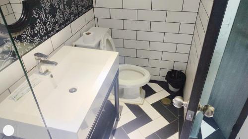 a bathroom with a white toilet and a sink at Venetian Poseidon Pool Hotel in Jomtien Beach