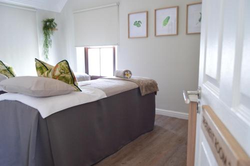 a bed with pillows on it in a room at Winelands Golf Lodges 24 in Stellenbosch