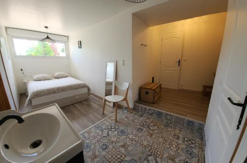 une salle de bain avec un lavabo et une chambre avec un lit dans l'établissement Au bout du chemin, à Châteauvieux