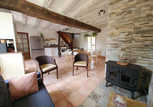 un salon avec une cheminée et une table avec des chaises dans l'établissement Au bout du chemin, à Châteauvieux