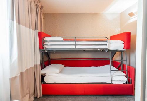 a bunk room with red bunk beds in it at B&B HOTEL Limoges 3 in Limoges