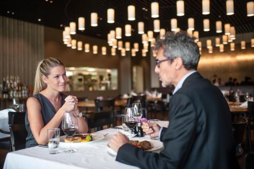 a man and woman sitting at a table in a restaurant at Seminarhotel CAMPUS SURSEE in Sursee