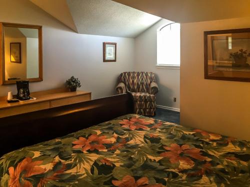 a hotel room with a bed and a chair at Bent Tree Motel in Emory