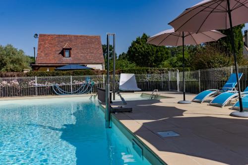 une piscine avec des chaises et un parasol dans l'établissement Maison Fleurie, à Castelnaud-la-Chapelle