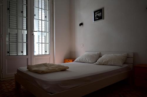 un letto in una camera da letto con due finestre di FRONT DE MER PLAGE DIRECT T4 8 Personnes ad Argelès-sur-Mer