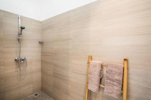 Un baño con ducha y dos toallas. en Villa Rumah Rindu, en Lovina