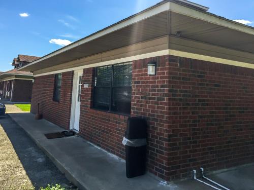 a brick building with a trash can next to it at Bent Tree Motel in Emory