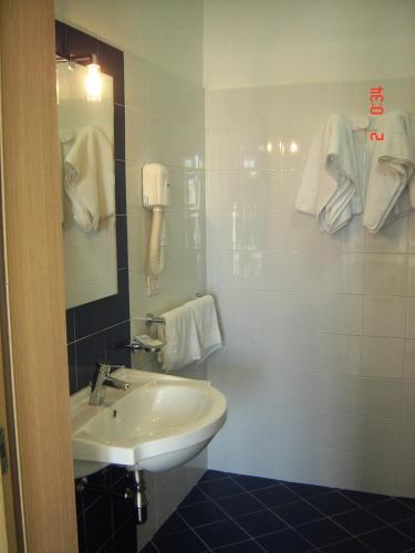 a bathroom with a sink and a mirror and towels at Il Sole Il Mare Il Vento in Torre Lapillo