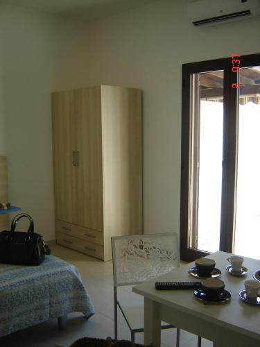 a room with a table and a chair and a cabinet at Il Sole Il Mare Il Vento in Torre Lapillo