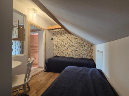 a small bedroom with a bed and a table and a window at Lägenhet-vindsvåning i centrala öregrund in Öregrund