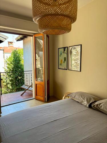 ein Schlafzimmer mit einem Bett und einer Tür zu einem Balkon in der Unterkunft La casina del lago vicino al bosco in Ghiffa