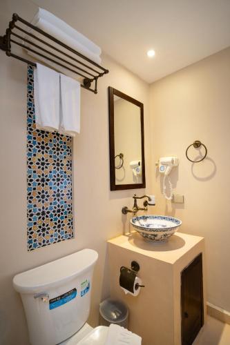 a bathroom with a toilet and a sink at Dewan Bangkok in Bangkok
