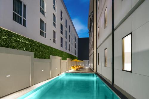 a swimming pool in the middle of a building at Quest Vibe Dewi Sri Bali in Legian