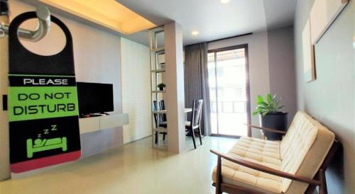 a living room with a couch and a tv at Silom Studios in Bangkok