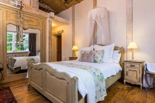 a bedroom with a large bed and a mirror at Marlborough B & B in Tuamarina
