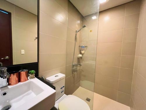 a bathroom with a shower and a toilet and a sink at Sharon's Island - Newcoast Boracay in Boracay