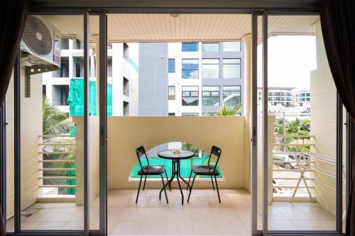 a patio with a table and chairs on a balcony at OK Phuket in Kata Beach