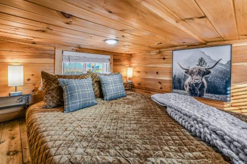a large bed in a room with wooden walls at Sojourn Lodging in Sevierville
