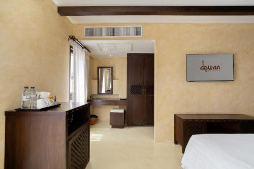 a hotel room with a bed and a bathroom at Dewan Bangkok in Bangkok