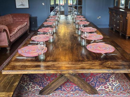 a long wooden table with plates on it at The Retreat at Glanrannell Park House in Llanwrda