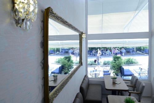 um espelho num quarto com uma mesa e cadeiras em Phidias Hotel by Oniro em Atenas