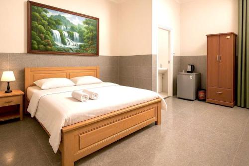 a bedroom with a bed with two towels on it at Nam Hội An Hotel - Near Vinpearl Nam Hội An in Tịch An (1)