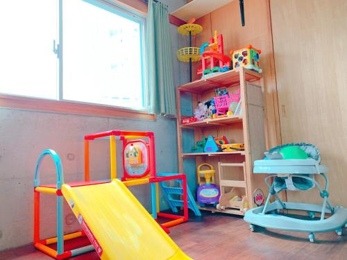 a play room with a slide and other toys at terrace sakashita in Naha