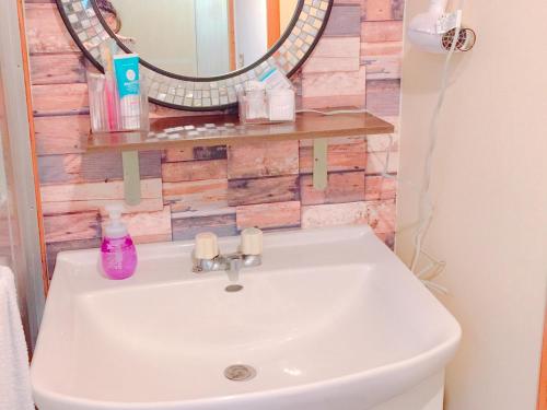a white sink in a bathroom with a mirror at terrace sakashita in Naha