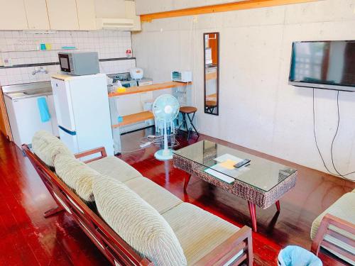 a living room with a couch and a table at terrace sakashita in Naha