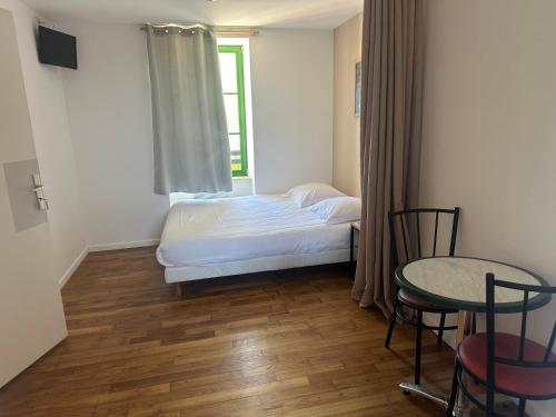 a bedroom with a bed and a table and a window at CHAMBRES / BEDROOM in Pleine-Fougères