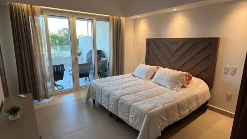 a bedroom with a large bed and a balcony at Departamento TerraMar Flamingos in Nuevo Vallarta