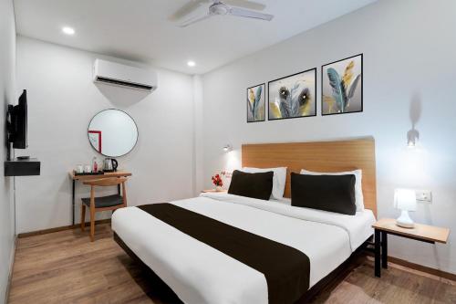 a hotel room with a large bed and a mirror at Super Townhouse Gomti Nagar Sector 6 Near Ekana Stadium in Lucknow