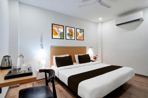 a bedroom with a large bed and a desk with a chair at Super Townhouse Gomti Nagar Sector 6 Near Ekana Stadium in Lucknow