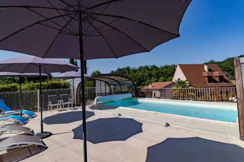 une piscine avec deux parasols et une piscine dans l'établissement Maison Liz, à Castelnaud-la-Chapelle