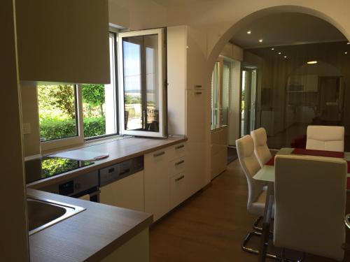 a kitchen with white cabinets and a table with chairs at Apartments & Rooms Marina in Dramalj