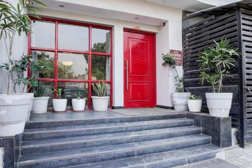 a red door on a house with potted plants at Super Townhouse Gomti Nagar Sector 6 Near Ekana Stadium in Lucknow