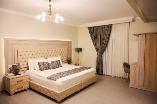 a bedroom with a large bed and a window at Famissi Suites in Kalabaka