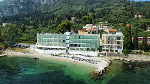 a hotel on a beach next to the water at Corfu Maris in Benitses