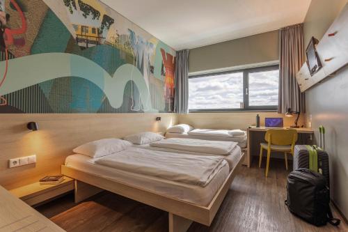 Postel nebo postele na pokoji v ubytování MEININGER Hotel Berlin Airport