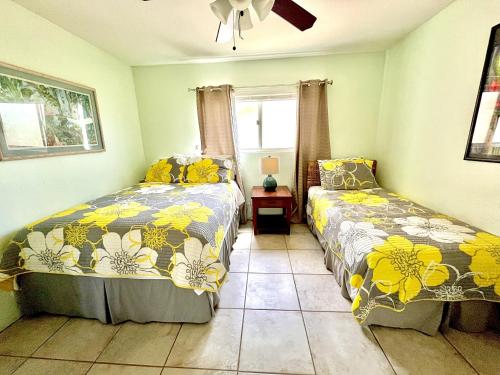 a bedroom with two beds and a window at Menehune Shores 227 condo in Kihei