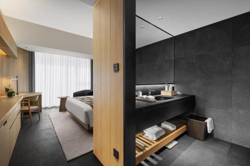 a bathroom with a sink and a bed in a room at Chengdu Airport International Conference Center Hotel in Chengdu
