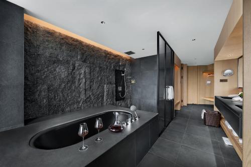 a bathroom with a black tub with wine glasses at Chengdu Airport International Conference Center Hotel in Chengdu