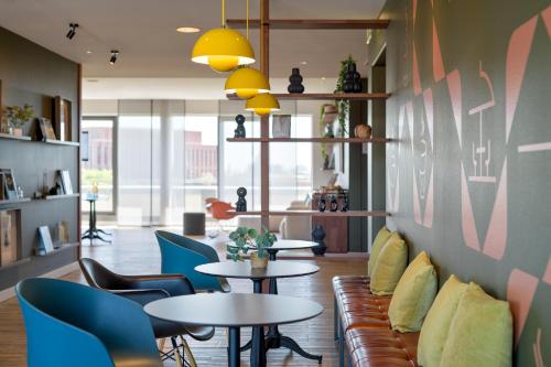 a room with tables and chairs and a couch at Mercure Hotel Hannover Mitte in Hannover