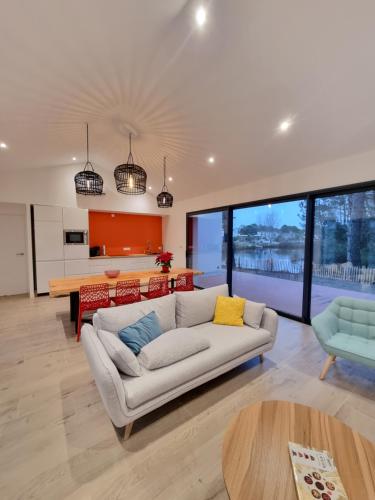 un salon avec un canapé et une table dans l'établissement Maison design en bord de lac, à Saint-Jean-de-Monts