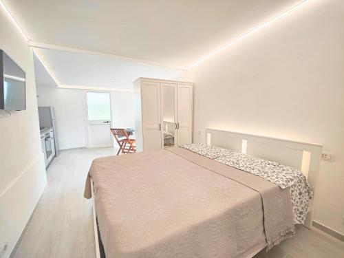 une chambre avec un lit dans une pièce blanche dans l'établissement Il Posticino House in Marina, Garden and Veranda, à Marina di Massa