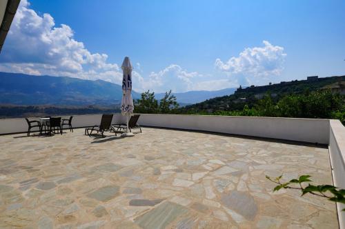 a patio with a table and chairs and an umbrella at Jons Apartment in Gjirokastër