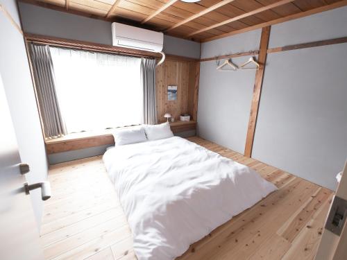 a bedroom with a white bed and a window at junos in Nahari
