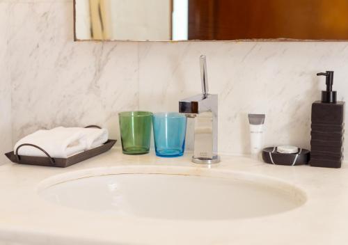 a bathroom sink with various items on top of it at Fashion Avenue Dubai Mall in Dubai