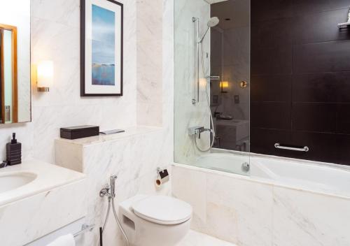 a bathroom with a toilet and a sink and a shower at Fashion Avenue Dubai Mall in Dubai